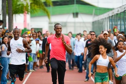 Bolt brinca de correr com jovens atletas da Vila Olímpica da Mangueira / Foto: Rio 2016 / Alex Ferro