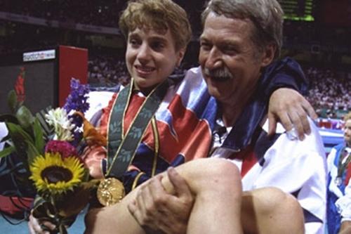 Kerri Strug é carregada pelo técnico com a medalha de ouro; ginasta saltou com tornozelo quebrado em Atlanta 1996 / Foto: Divulgação / COI